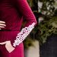 Woman wearing a burgandy and lace midi dress with black tights and sole society back boots. She is standing outside of Inherit Clothing Company.