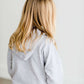 Girl wearing a french terry hoodie with a white button shirt underlay