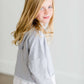 Girl wearing a french terry hoodie with a white button shirt underlay