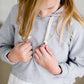 Girl wearing a french terry hoodie with a white button shirt underlay