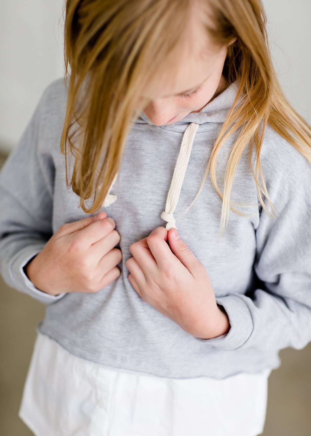 Girl wearing a french terry hoodie with a white button shirt underlay