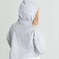 Girl wearing a french terry hoodie with a white button shirt underlay