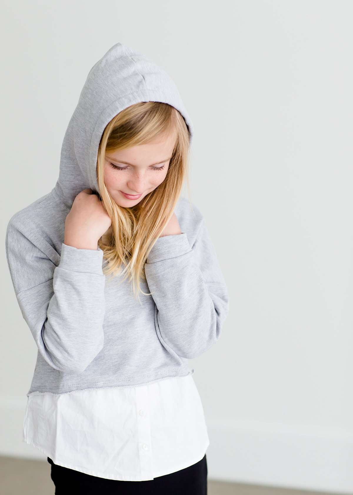 Girl wearing a french terry hoodie with a white button shirt underlay