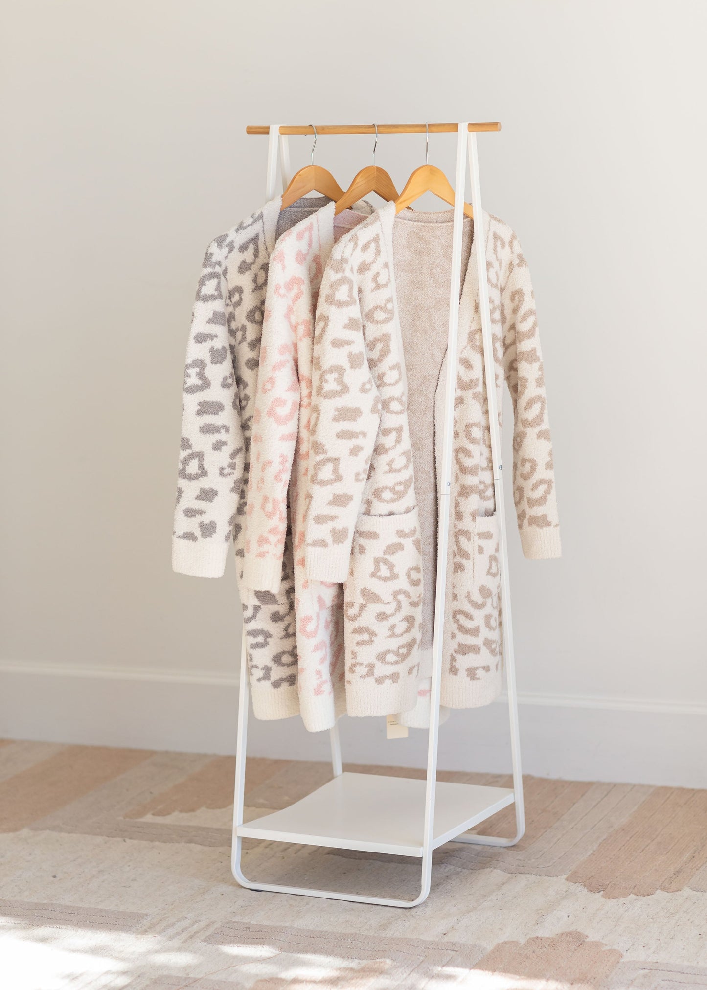 Leopard Print Robe comes in 3 color options grey, pink and beige with a leopard print, fleece style, with a tie waist, and is hip length.