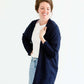 Woman wearing a lightweight knit cardigan in navy, taupe or cream. 