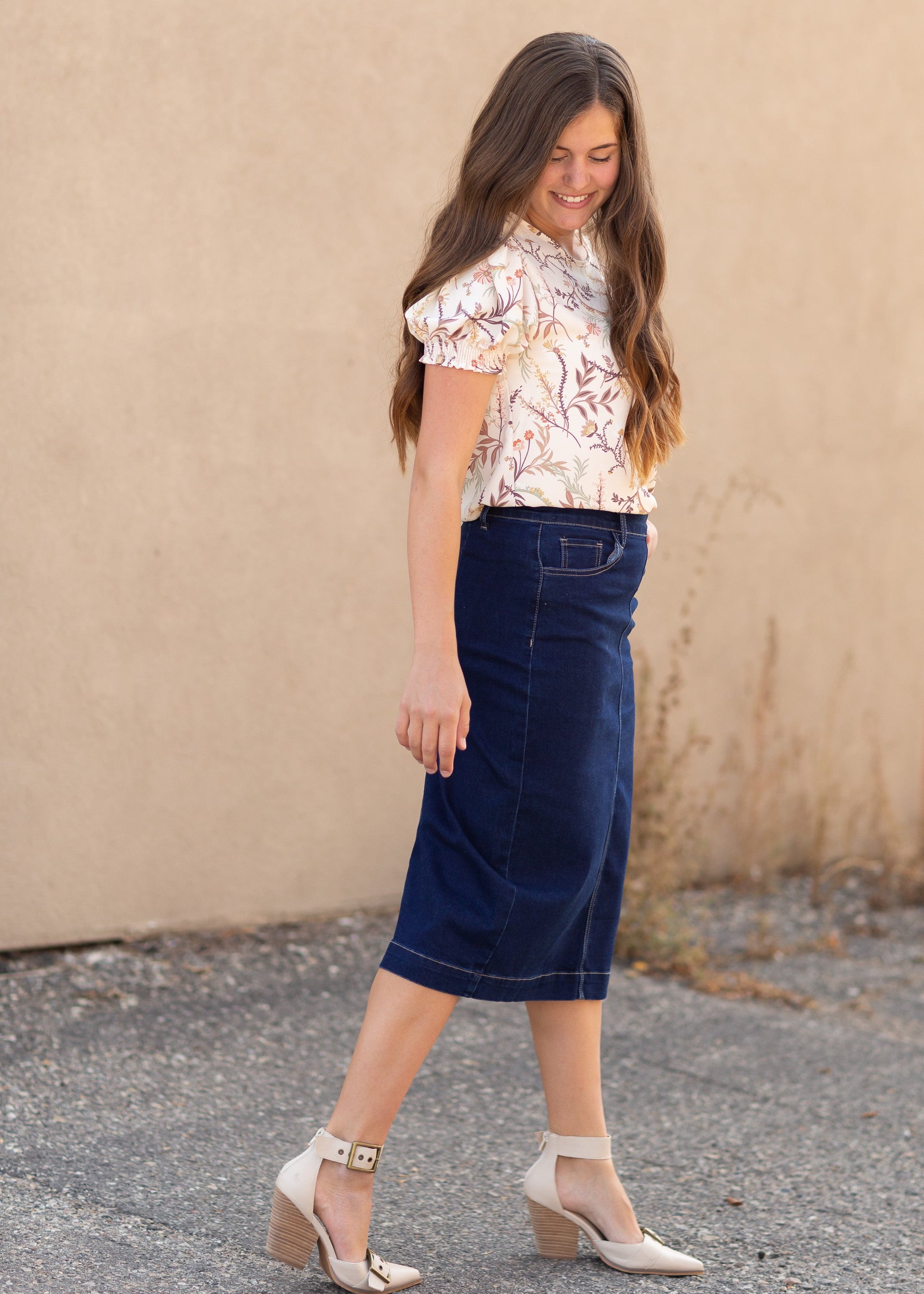 A dark blue denim midi skirt with contrast stitching and a side sip closure.