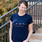 Young woman wearing a love is patient king james version bible verse graphic navy tee