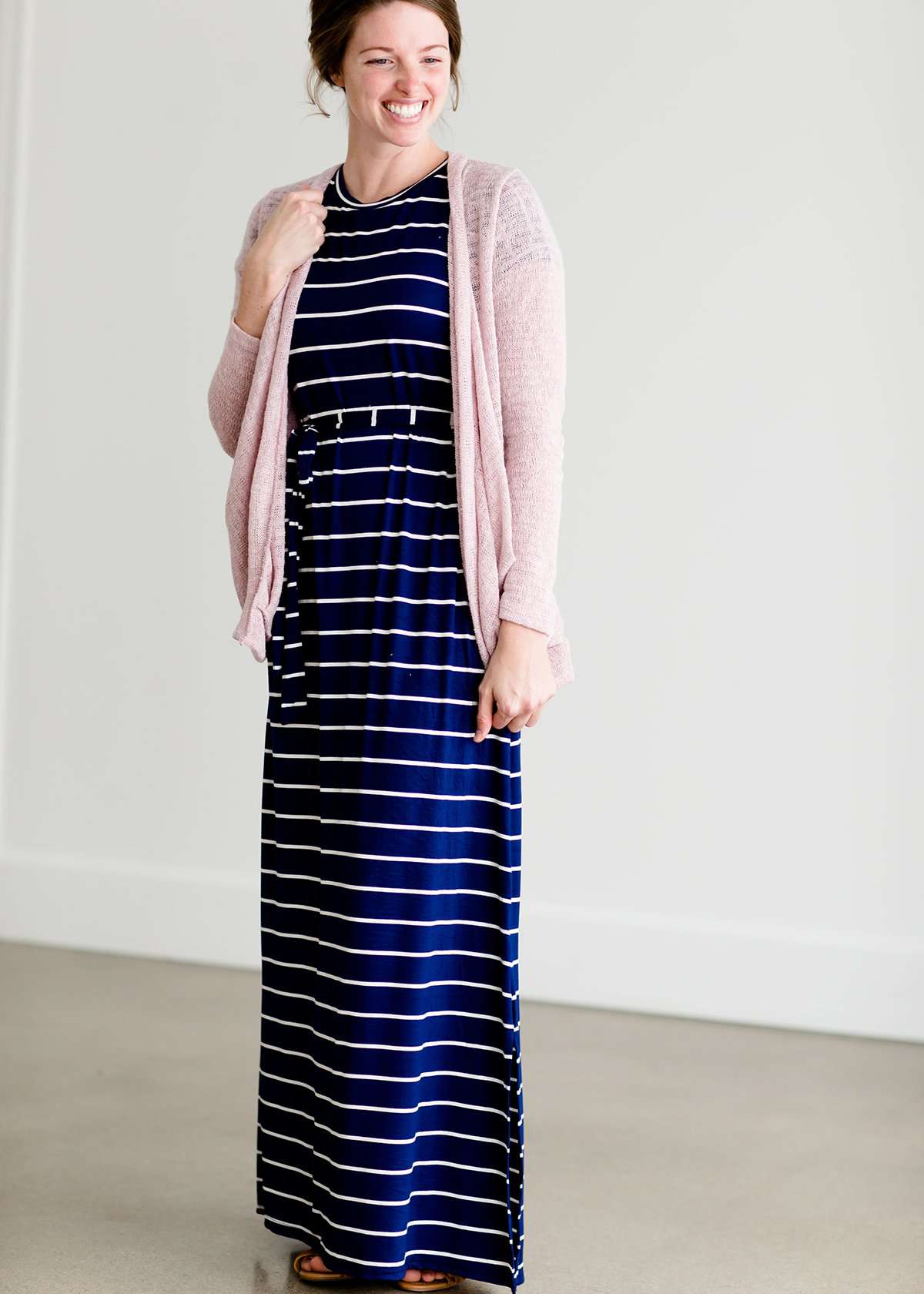 Woman wearing a modest navy and white stripe maxi dress that has cap sleeves and a fabric belt that is detachable!