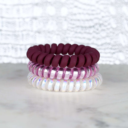 Matte colored bugandy, pink and white hot line hair ties that coil