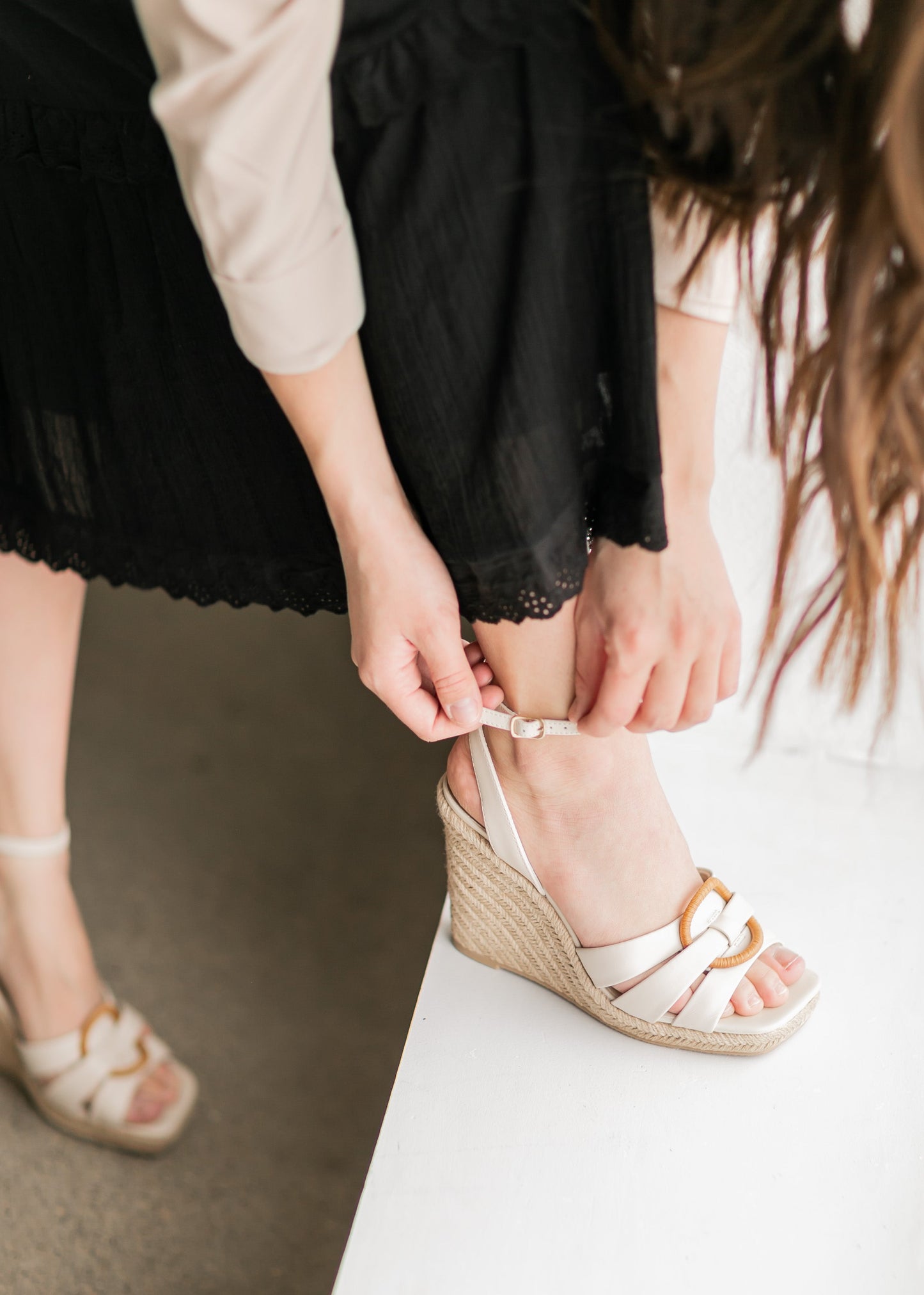 An ivory leather wedge sandal, with an ankle strap and circle toe band detail.
