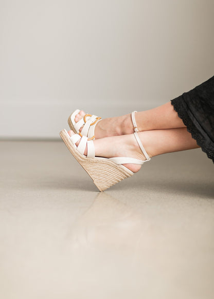 An ivory leather wedge sandal, with an ankle strap and circle toe band detail.