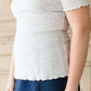 woman wearing a gray mock neck short sleeve top