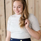 woman wearing a gray mock neck short sleeve top
