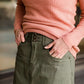 Woman wearing an olive, long modest cotton skirt. This skirt has no slit and is paired with a mauve sweater.