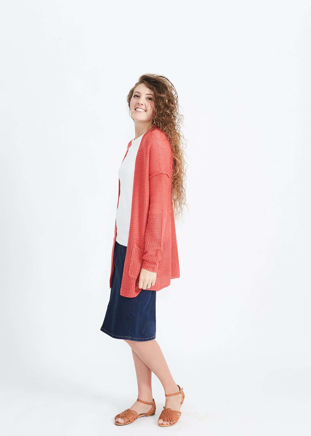 Woman wearing a green or coral waffle knit cardigan