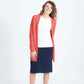 Woman wearing a green or coral waffle knit cardigan