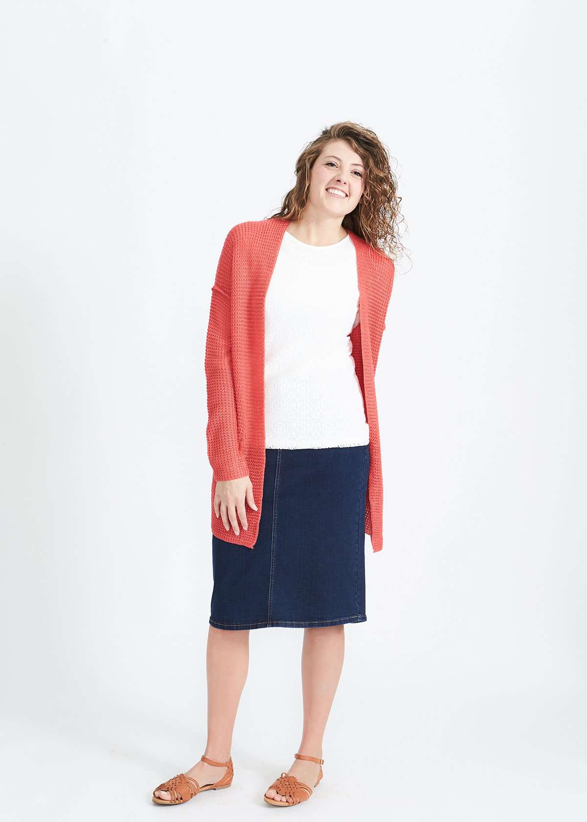 Woman wearing a green or coral waffle knit cardigan