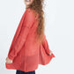 Woman wearing a green or coral waffle knit cardigan