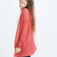 Woman wearing a green or coral waffle knit cardigan