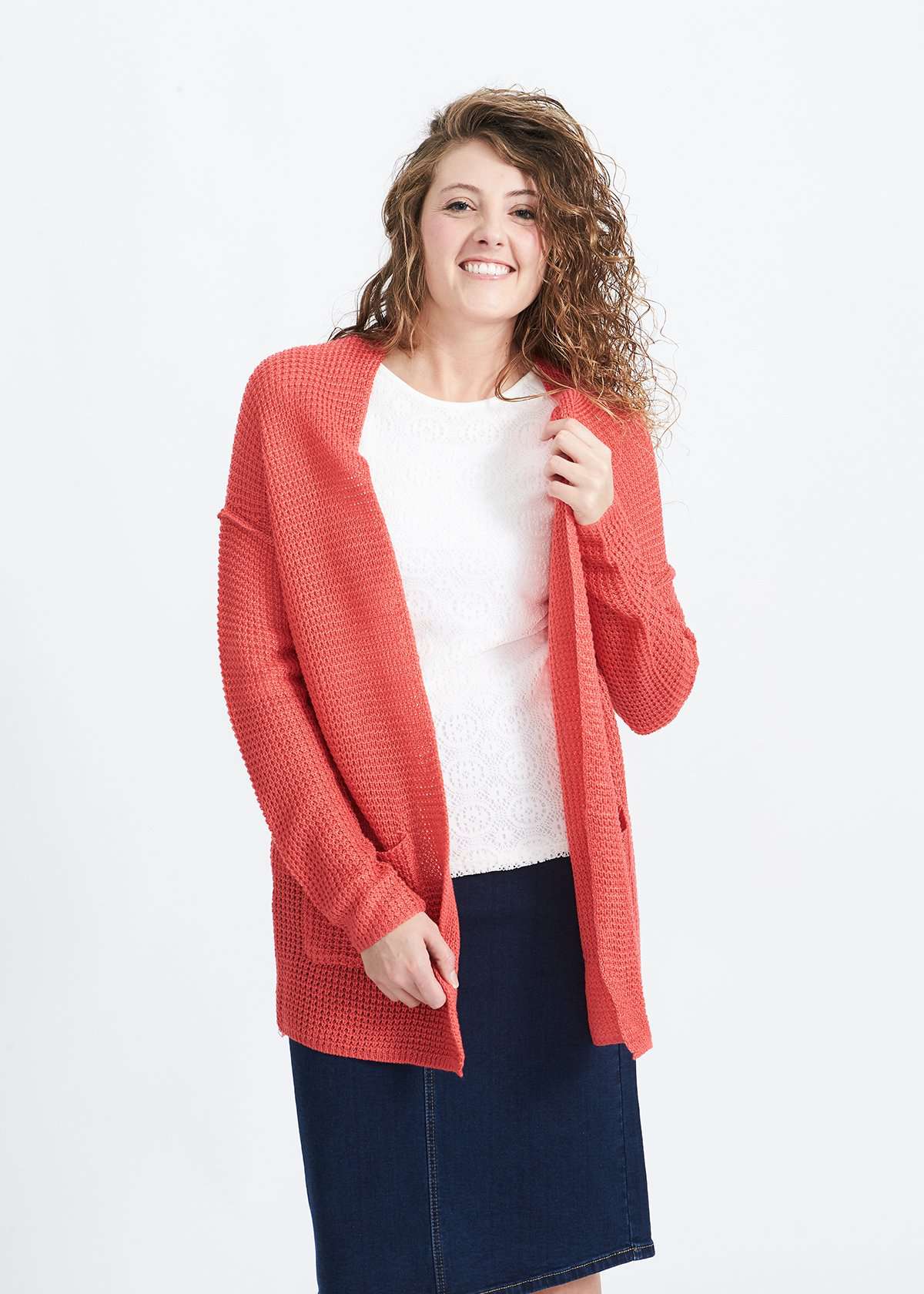 Woman wearing a green or coral waffle knit cardigan