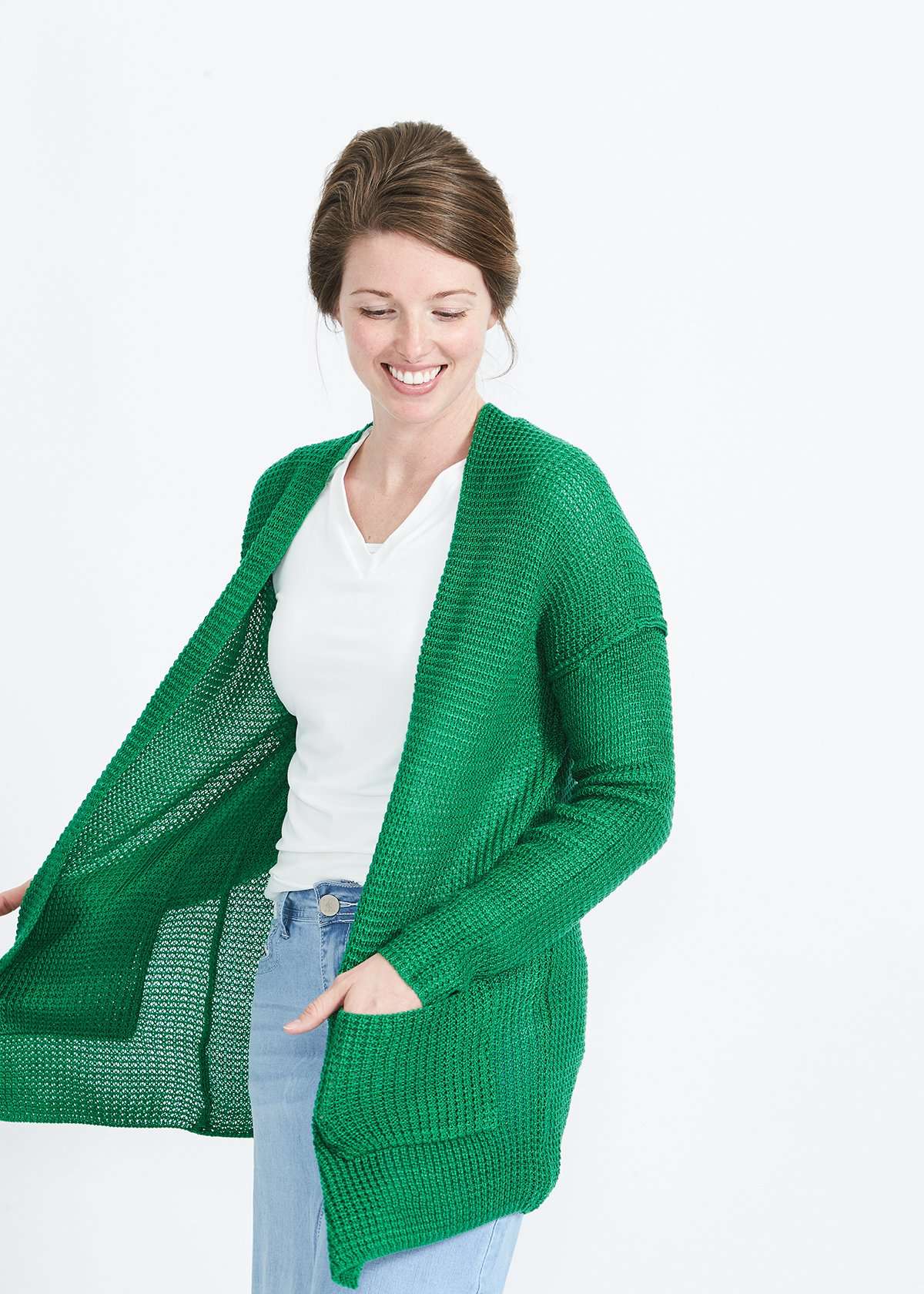 Woman wearing a green or coral waffle knit cardigan