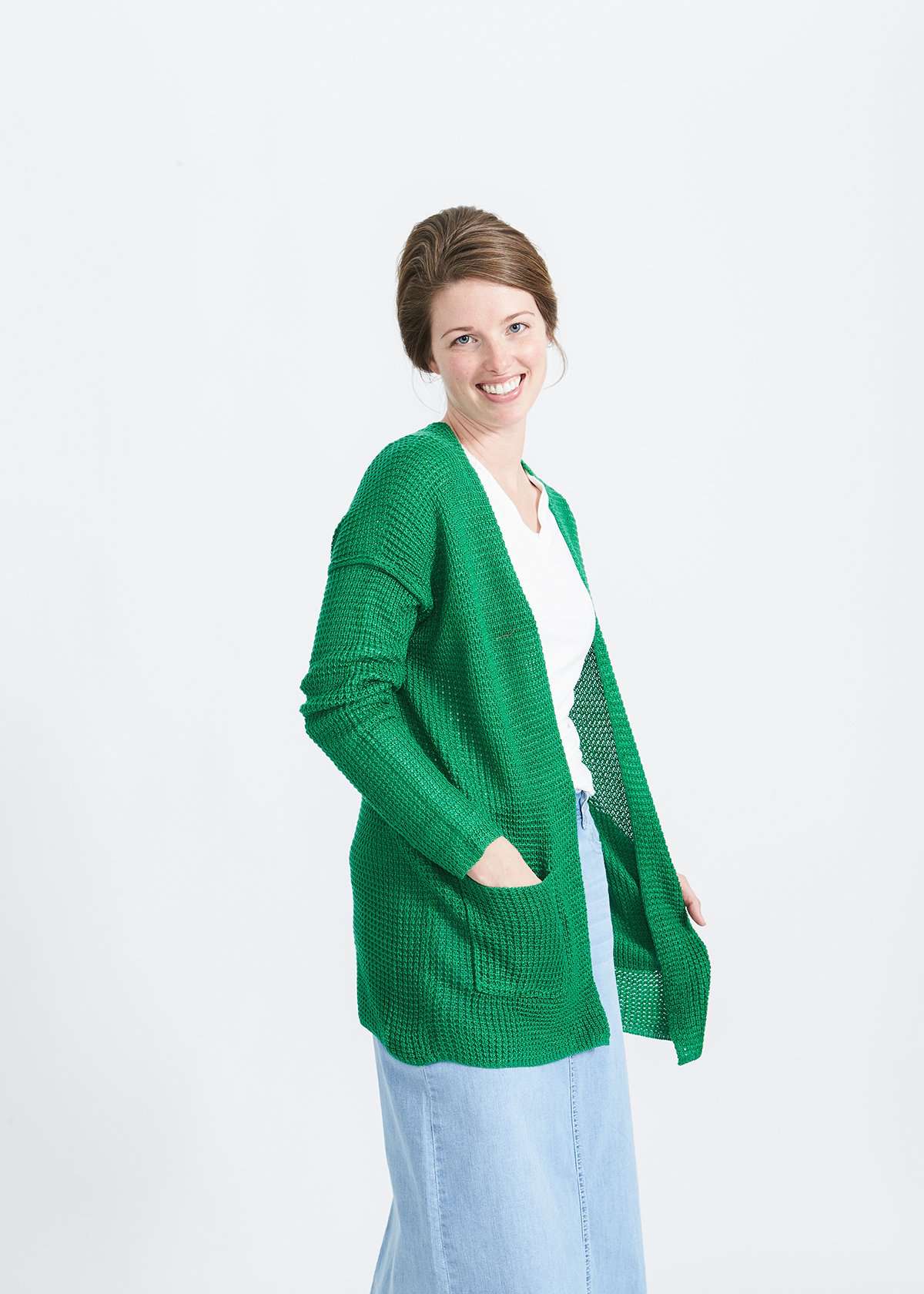 Woman wearing a green or coral waffle knit cardigan