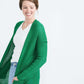 Woman wearing a green or coral waffle knit cardigan