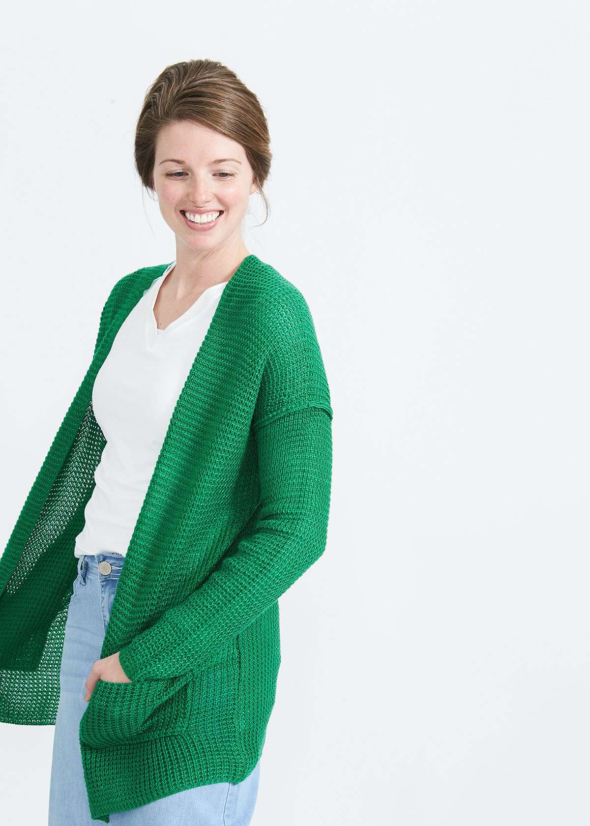 Woman wearing a green or coral waffle knit cardigan