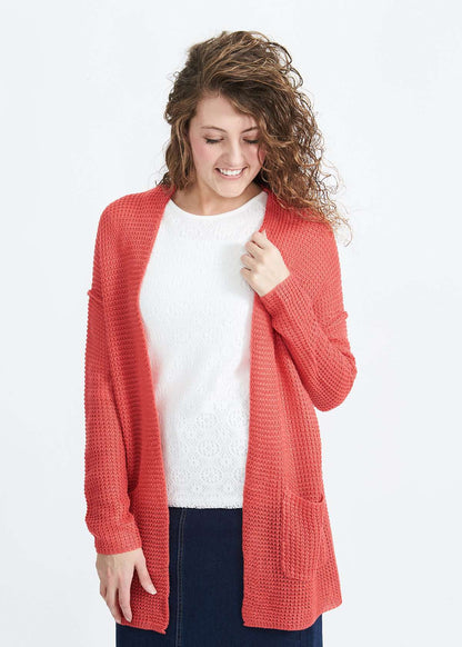 Woman wearing a green or coral waffle knit cardigan