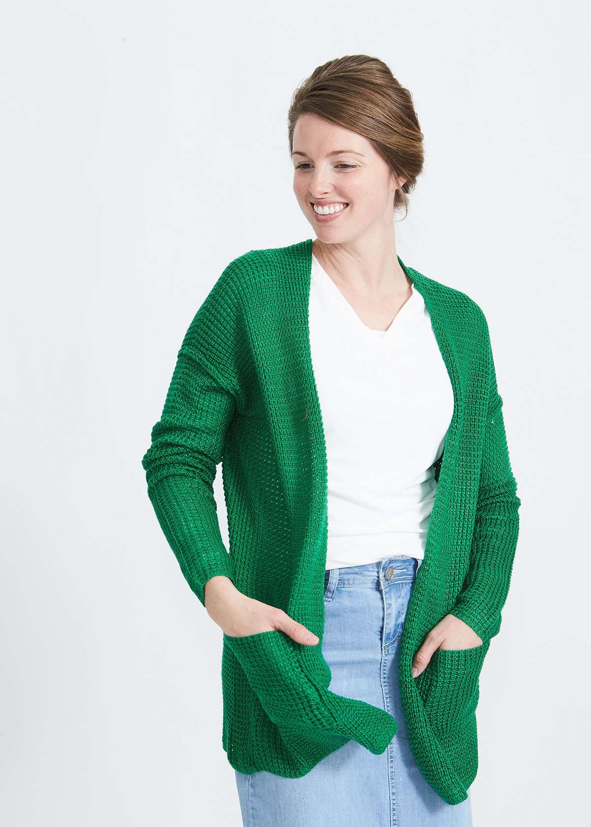 Woman wearing a green or coral waffle knit cardigan