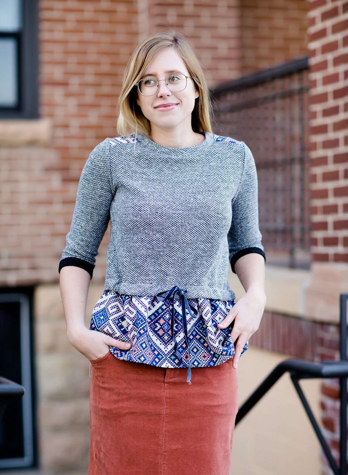 Young woman wearing a polyester navy print sweater like modest peplum top
