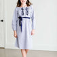 Tween wearing a navy boho pin stripe peasant dress with a self tie belt