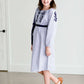 Tween wearing a navy boho pin stripe peasant dress with a self tie belt