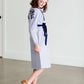 Tween wearing a navy boho pin stripe peasant dress with a self tie belt