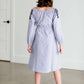 Tween wearing a navy boho pin stripe peasant dress with a self tie belt