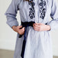 Tween wearing a navy boho pin stripe peasant dress with a self tie belt