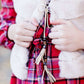 Young girl wearing a modest red plaid midi dress with balloon style sleeves. This dress also features a self tie fabric waist and is lined.