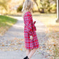 Young girl wearing a modest red plaid midi dress with balloon style sleeves. This dress also features a self tie fabric waist and is lined.