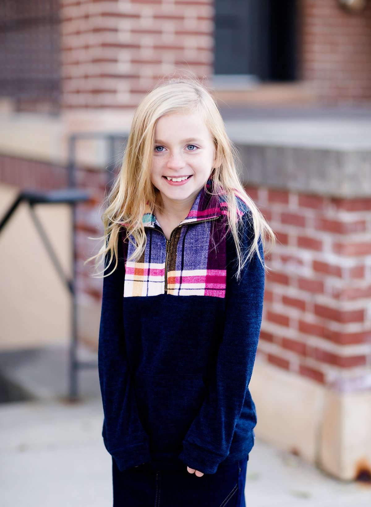 This half zip pullover features a front pouch pocket and a beautiful color block print of fuchsia, teal and mustard!  This young girl is also matching her mother in a mommy and me style.