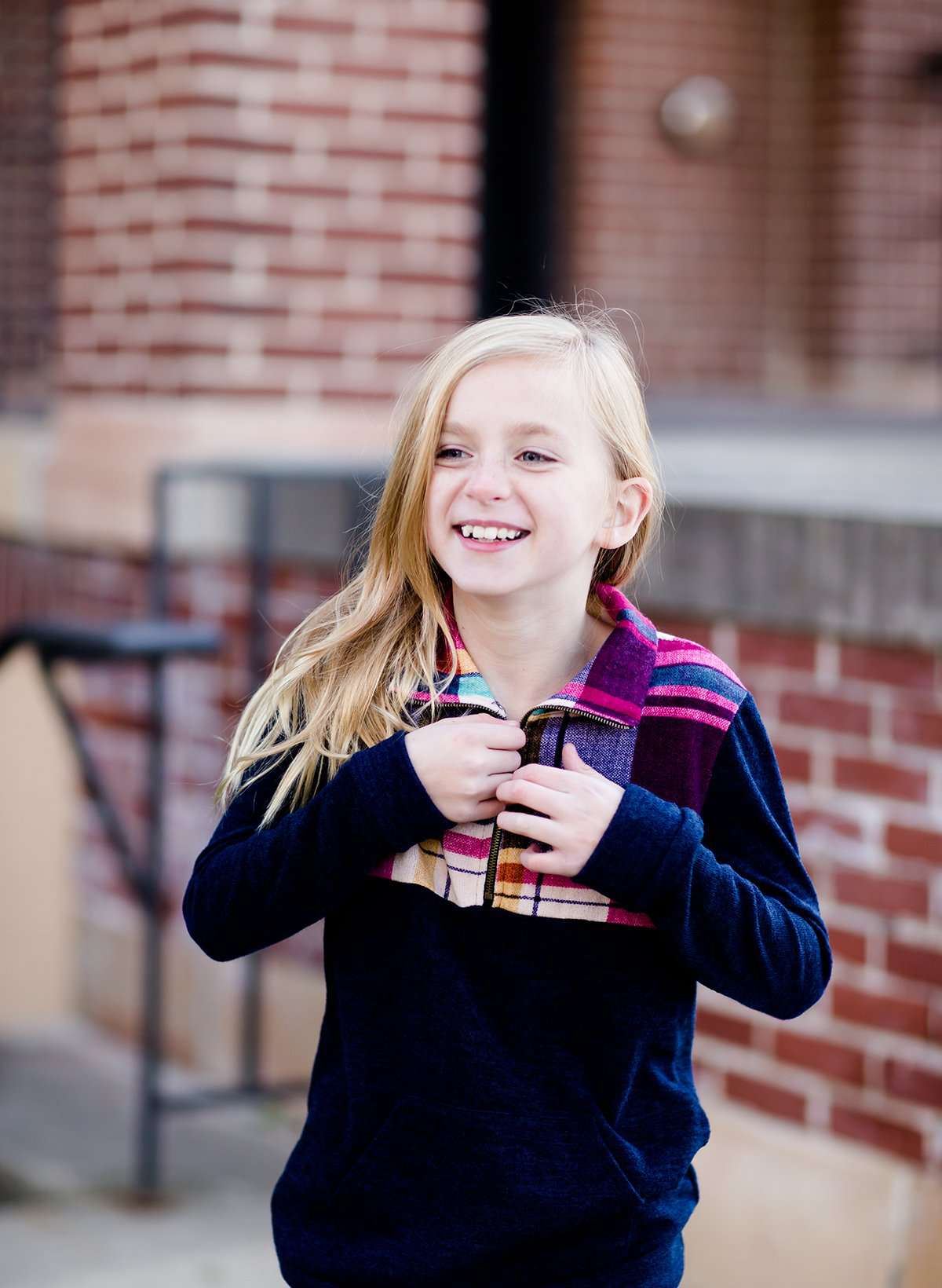 This half zip pullover features a front pouch pocket and a beautiful color block print of fuchsia, teal and mustard!  This young girl is also matching her mother in a mommy and me style.