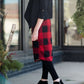 Woman wearing a modest plaid sweater style midi skirt. This skirt has an elastic waist and a tie front. It is paired with tights and short ankle boots.