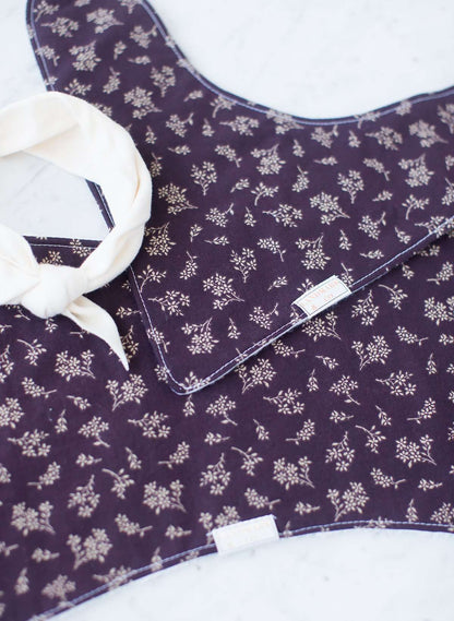 This is a purple and floral baby burp cloth, baby bandana and headband gift set.