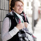 Woman wearing an anorak quilted vest with a zipper and hood. This vest comes in olive or black with gray accents.
