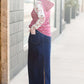 Woman wearing a long denim jean skirt that has a dark wash and a light wash. this is a long modest jean skirt.