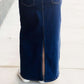 Woman wearing a long denim jean skirt that has a dark wash and a light wash. this is a long modest jean skirt.