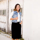 Woman wearing a black below the knee denim midi skirt.