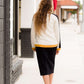 Woman wearing a black below the knee denim midi skirt.