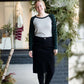 Woman wearing a black below the knee denim midi skirt.