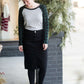 Woman wearing a black below the knee denim midi skirt.