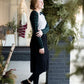 Woman wearing a black below the knee denim midi skirt.